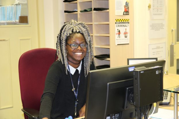 A Business Support Assistant sits in front of her desk